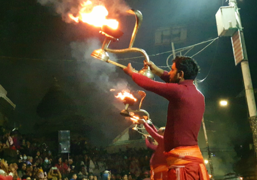 Drie hindoepriesters zwaaien met vuurlampen als lichtoffers aan Shiva in Pashupatinath, Kathamandu.