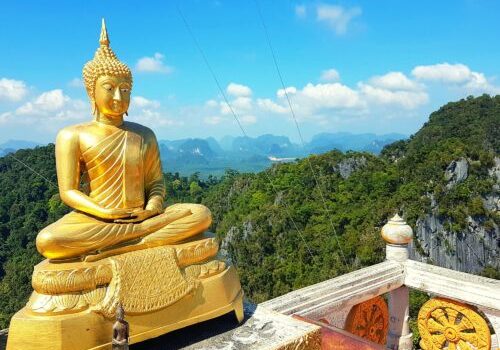 Beeld van Boeddha in lotushouding boven op de top van Tiger Cave Temple, Krabi, Thailand.