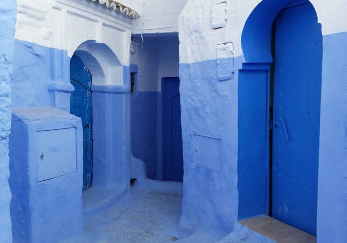 Drie blauwe deuren in een blauw geverfde straathoek in Chefchaouen, Marokko.